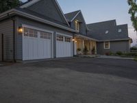 a grey three - car garage with the lights on next to it's entrance