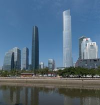 tall buildings near the water with blue skies in the background from a river in front