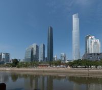 tall buildings near the water with blue skies in the background from a river in front