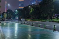 a city street with buildings and neon lights at night time in hong china as seen from an empty city highway