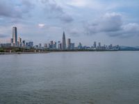 the water has very large chunks of blue in it and a skyline of large buildings in the background