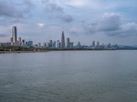 the water has very large chunks of blue in it and a skyline of large buildings in the background