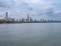 the water has very large chunks of blue in it and a skyline of large buildings in the background