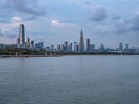 the water has very large chunks of blue in it and a skyline of large buildings in the background