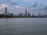 the water has very large chunks of blue in it and a skyline of large buildings in the background