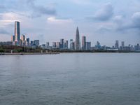 the water has very large chunks of blue in it and a skyline of large buildings in the background