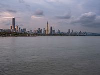 the water has very large chunks of blue in it and a skyline of large buildings in the background