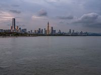 the water has very large chunks of blue in it and a skyline of large buildings in the background