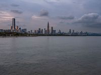 the water has very large chunks of blue in it and a skyline of large buildings in the background