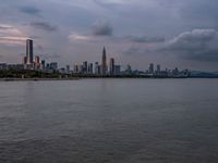 the water has very large chunks of blue in it and a skyline of large buildings in the background