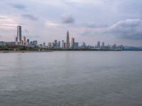 the water has very large chunks of blue in it and a skyline of large buildings in the background