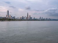 the water has very large chunks of blue in it and a skyline of large buildings in the background