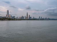 the water has very large chunks of blue in it and a skyline of large buildings in the background