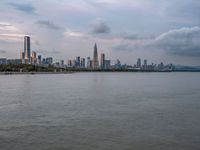 the water has very large chunks of blue in it and a skyline of large buildings in the background