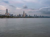 the water has very large chunks of blue in it and a skyline of large buildings in the background