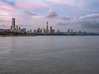 the water has very large chunks of blue in it and a skyline of large buildings in the background