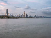 the water has very large chunks of blue in it and a skyline of large buildings in the background