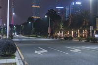 a city intersection at night with traffic lights and a couple people on motorcycles going to work