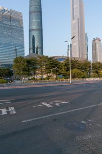 an empty street next to a very large tall building in the city, with a lot of people walking in the street