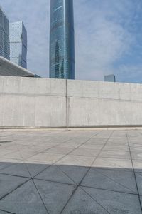 a man riding on top of a skateboard next to tall buildings filled with tall skyscrapers