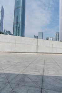 a man riding on top of a skateboard next to tall buildings filled with tall skyscrapers