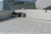 the man stands on the stairs in front of a large building that looks like a whale