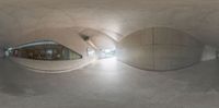 a fish eye view of a building from inside a very long tunnel, looking out