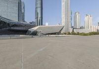 a concrete parking lot with buildings behind it and an open area for walking on it