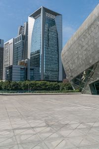 a man is on his skateboard in the middle of an empty square surrounded by many modern buildings