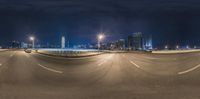 traffic passing over an empty highway and a big city skyline lit with street lights at night