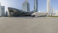 an outdoor area in a city with a building near by, and some buildings on the other side