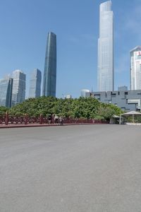 people are standing on a bridge with skyscrapers behind them in a city park and park