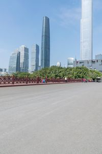 people are standing on a bridge with skyscrapers behind them in a city park and park