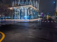 a street scene looking at a bus stop on a city street at night with lights on