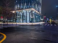 a street scene looking at a bus stop on a city street at night with lights on