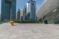 yellow fire hydrant in front of large, modern buildings and walkway in front of skyscrapers