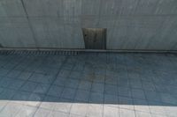 empty tile floor with door between walls and side stairss on building side, showing concrete floors and wall