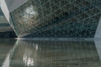 an image of a very interesting building reflected in the water of it's pond