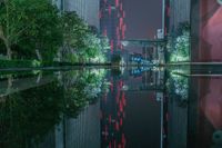 a city street with buildings and neon lights at night time in hong china as seen from an empty city highway