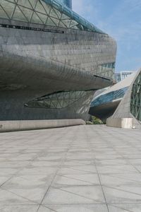 a person riding a skateboard across a cement plaza next to buildings and skylights