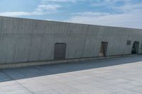 a person doing a skateboard trick in a large concrete building complex of a park