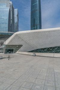 large building with two tall buildings sitting next to each other, in front of some buildings