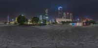 a night view of the city skyline from across a river bed area with water and buildings on the other side of the waterway