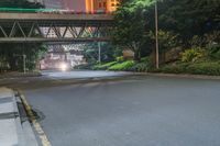 a city street with buildings and neon lights at night time in hong china as seen from an empty city highway