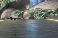 the walkway is filled with various people walking and sitting on benches that are made of steel