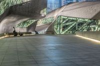 the walkway is filled with various people walking and sitting on benches that are made of steel