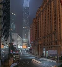 a city street with buildings and neon lights at night time in hong china as seen from an empty city highway