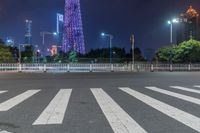 a city street with buildings and neon lights at night time in hong china as seen from an empty city highway