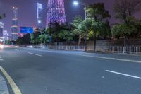 a city street with buildings and neon lights at night time in hong china as seen from an empty city highway