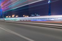 a city street with buildings and neon lights at night time in hong china as seen from an empty city highway